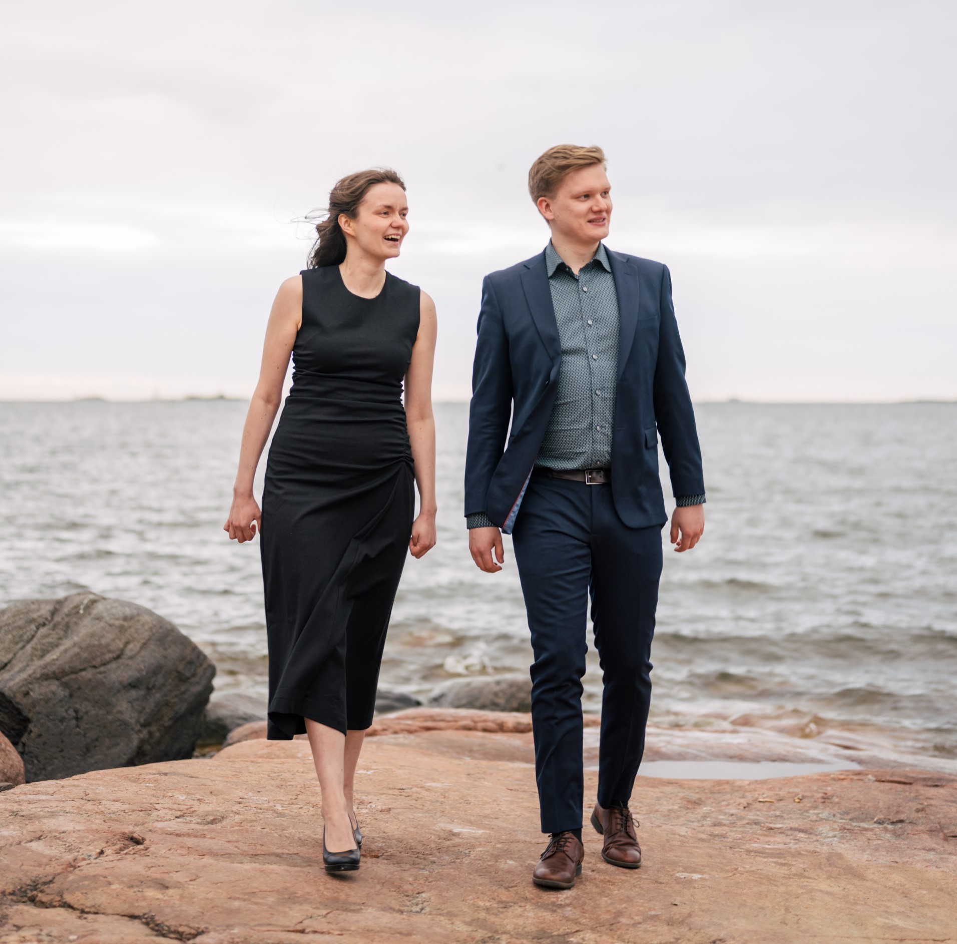 Kaisa Pulkkinen ja Paulus Hartikainen seisovat vierekkäin rantakallioilla.