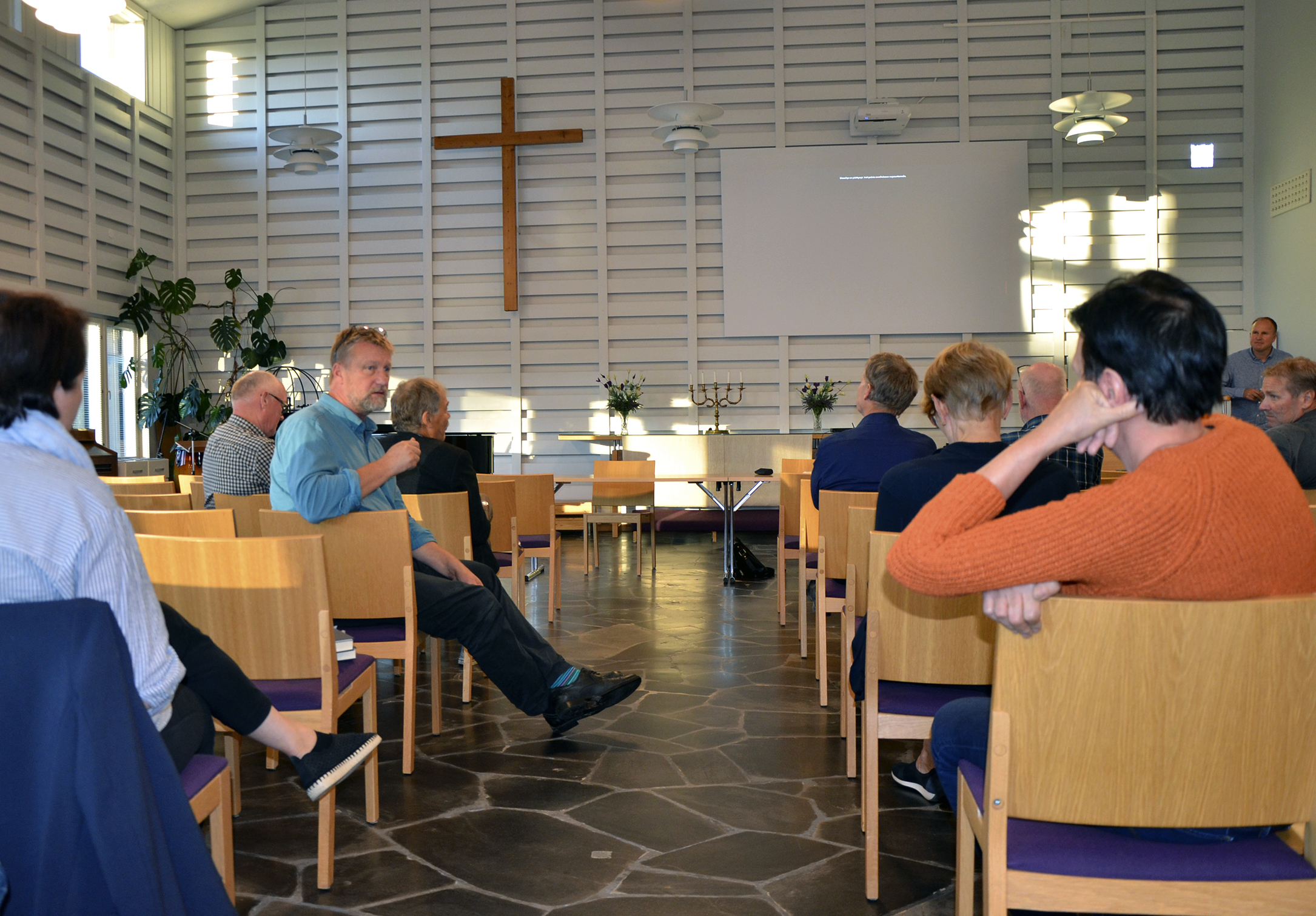 Tilaisuuden osallistujat istuvat salissa väljästi. Antti Lapinoja käyttää puheenvuoroa omalta paikaltaan.