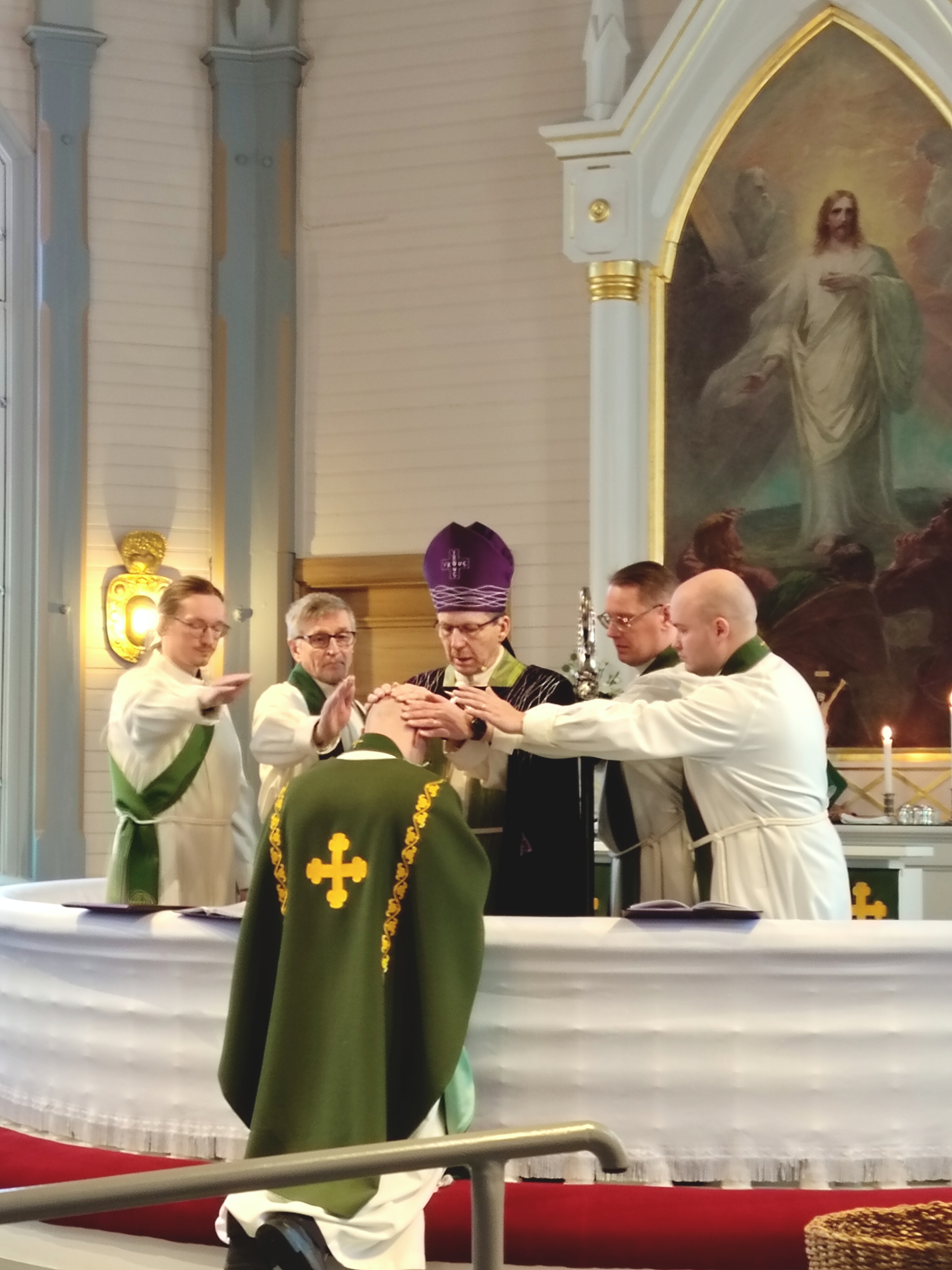 Kirkkoherra alttarilla siunattavana.