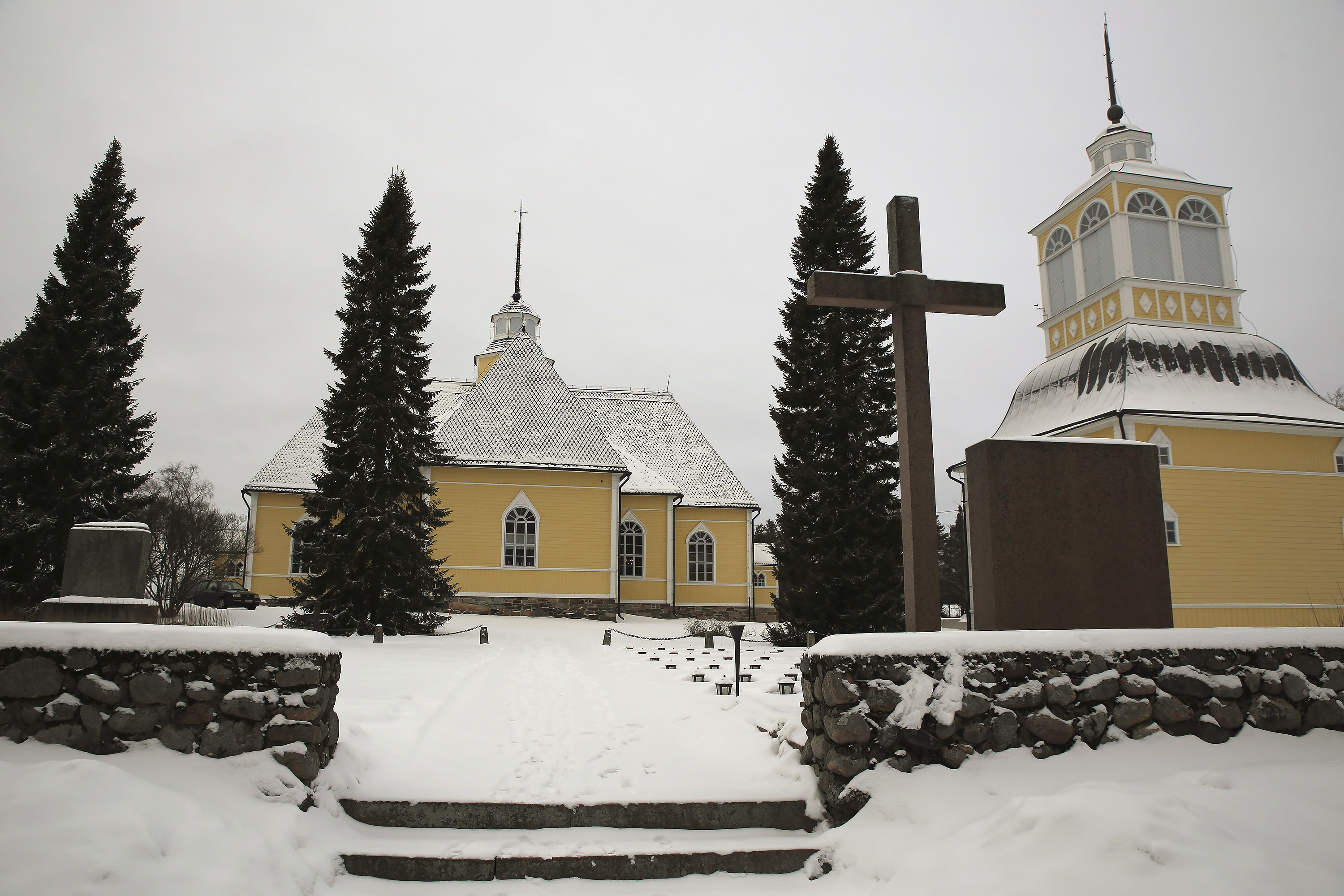 Lohtajan keltainen kirkko ja tapuli lumisessa maisemassa.